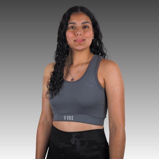 Top deportivo mujer VRS Flow gris oscuro, diseño ajustado y cómodo, ideal para yoga, running y pádel.